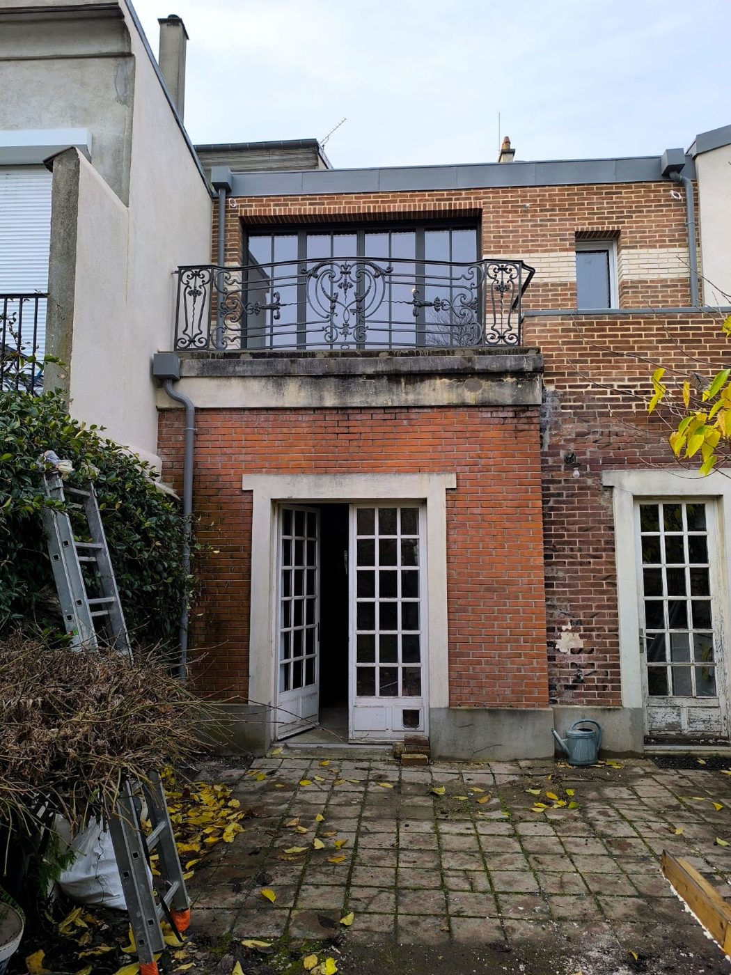 Façade en brique avec balcon en ferronnerie
