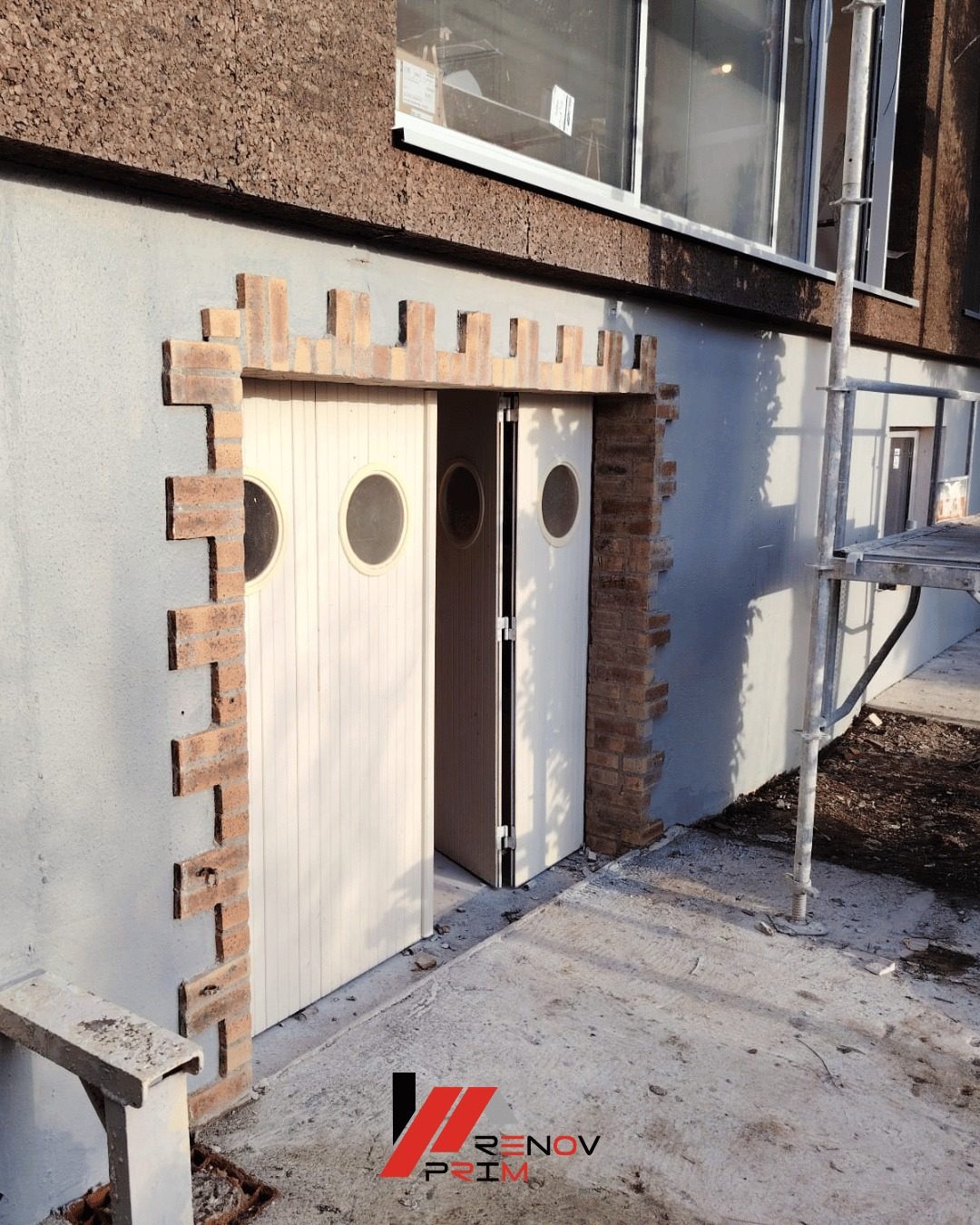 Porte à hublots avec encadrement en brique et façade enduit